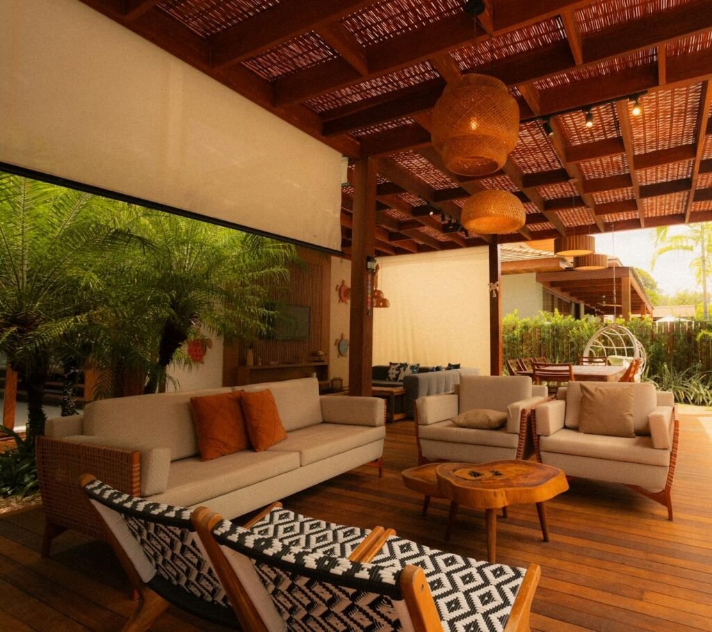 A stylish outdoor patio showcasing modern furniture and natural decor under a wooden pergola.