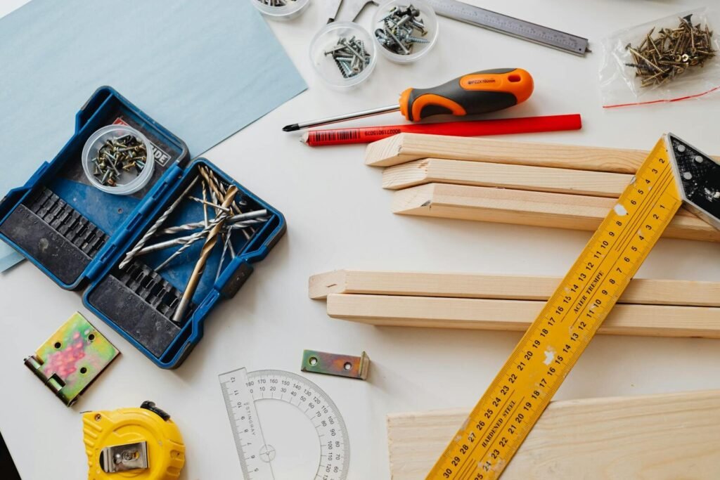A top view of various woodworking tools and materials on a white table.
