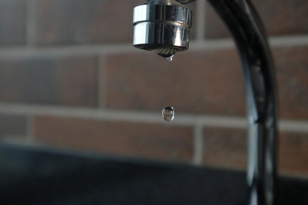 a faucet with a water drop hanging from it