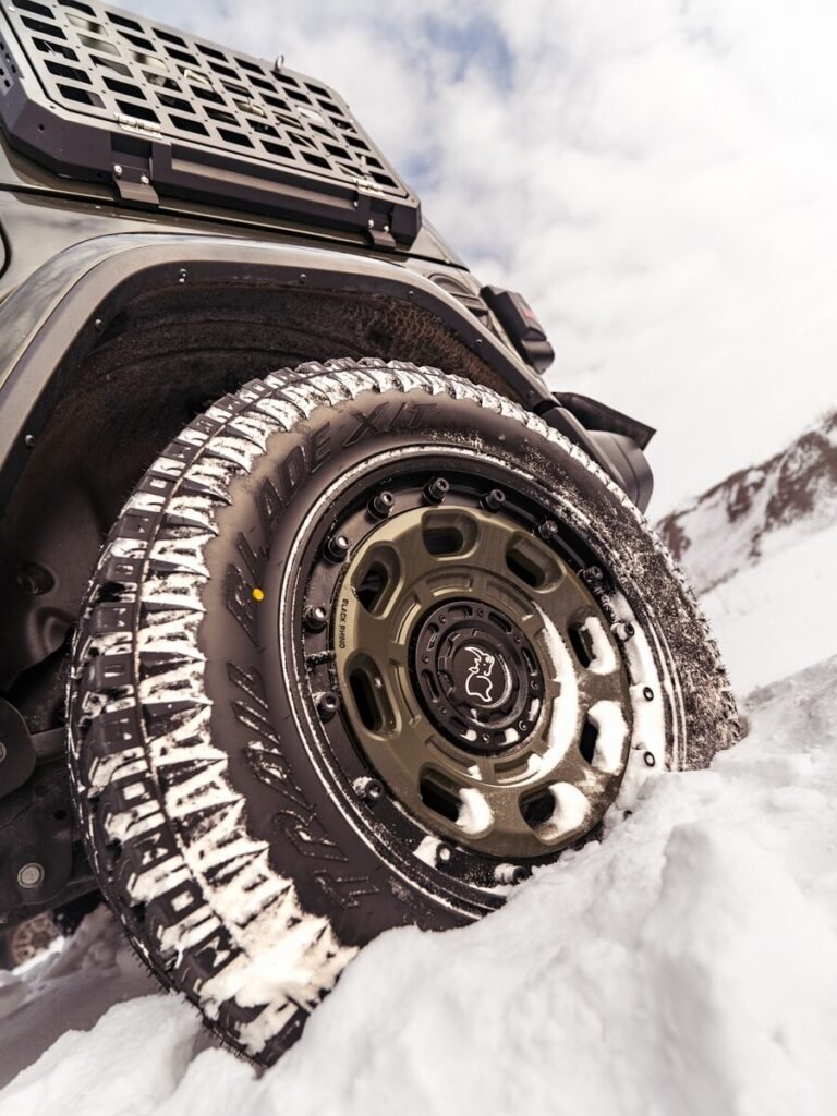Off-road vehicle driving through snow covered terrain