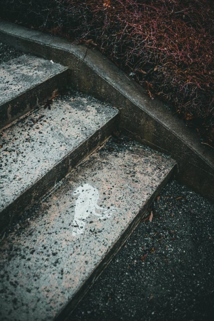 Close-up of textured concrete stairs with a unique water stain, capturing an abstract perspective.