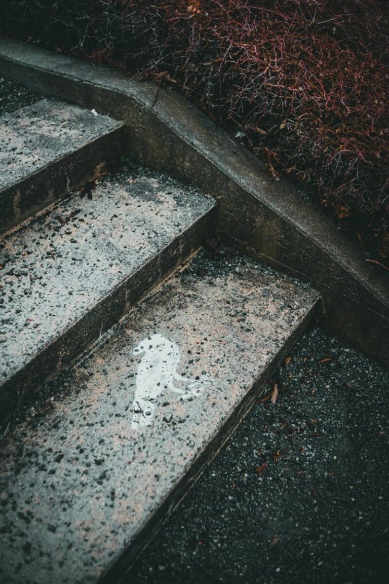 Close-up of textured concrete stairs with a unique water stain, capturing an abstract perspective.
