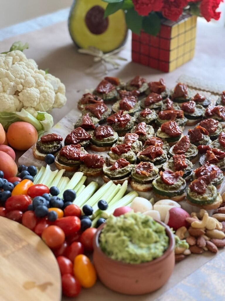 Colorful vegan platter with guacamole, veggies, and nuts for a healthy spread.