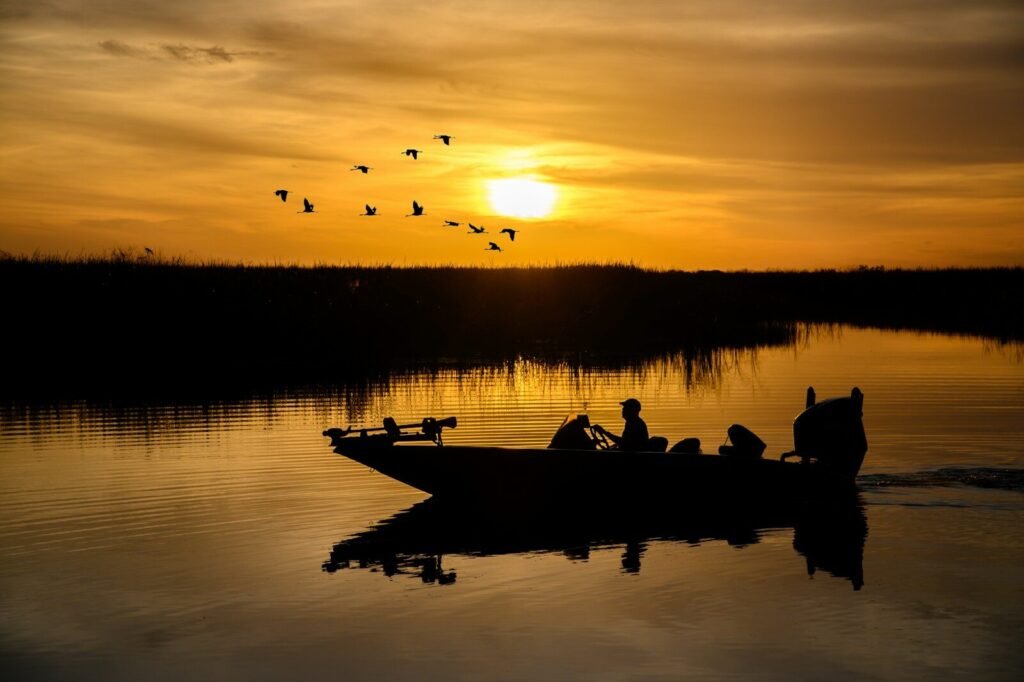 Best U.S. Lakes for Fishing; a group of people on a boat in the water with birds flying