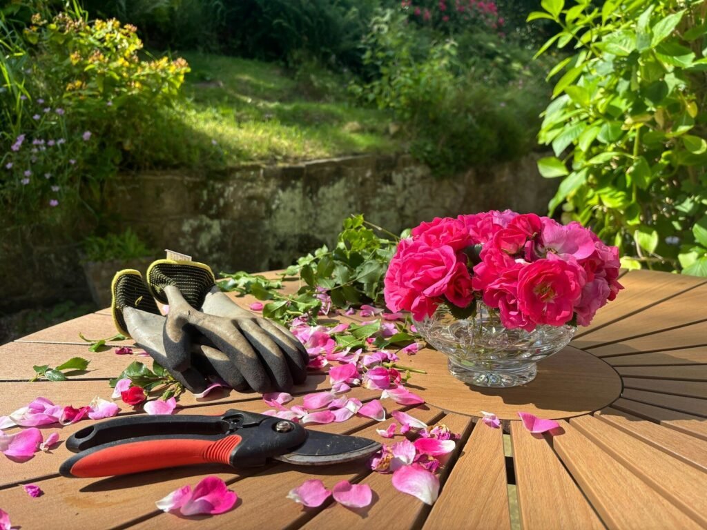 Explore Low-Maintenance Gardening with Perennial Flowerbeds 5 A wooden table topped with pink flowers and gardening utensils