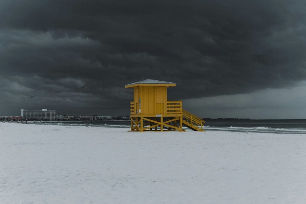 Top U.S. Beaches; a yellow lifeguard tower sitting on top of a sandy beach