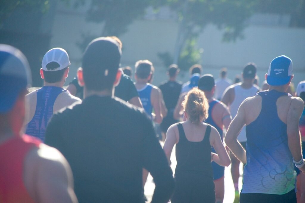 People running outdoors in bright, hazy sunlight.