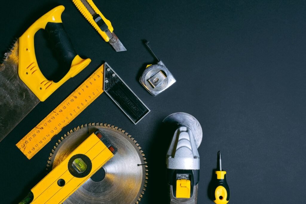 Milwaukee vs. DeWalt; A collection of construction tools arranged on a dark surface offering copy space.