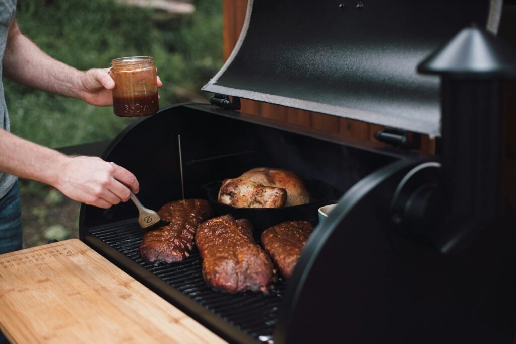 How to Choose the Right Smoker 3 choose the right smoker; person holding knife slicing meat on black grill