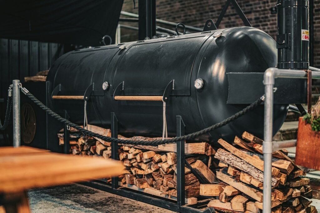 Smoke Ribs Like a Backyard Pitmaster; a large black tank sitting on top of a pile of wood